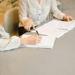 Personne qui signe un papier et une personne aidant cette dernière