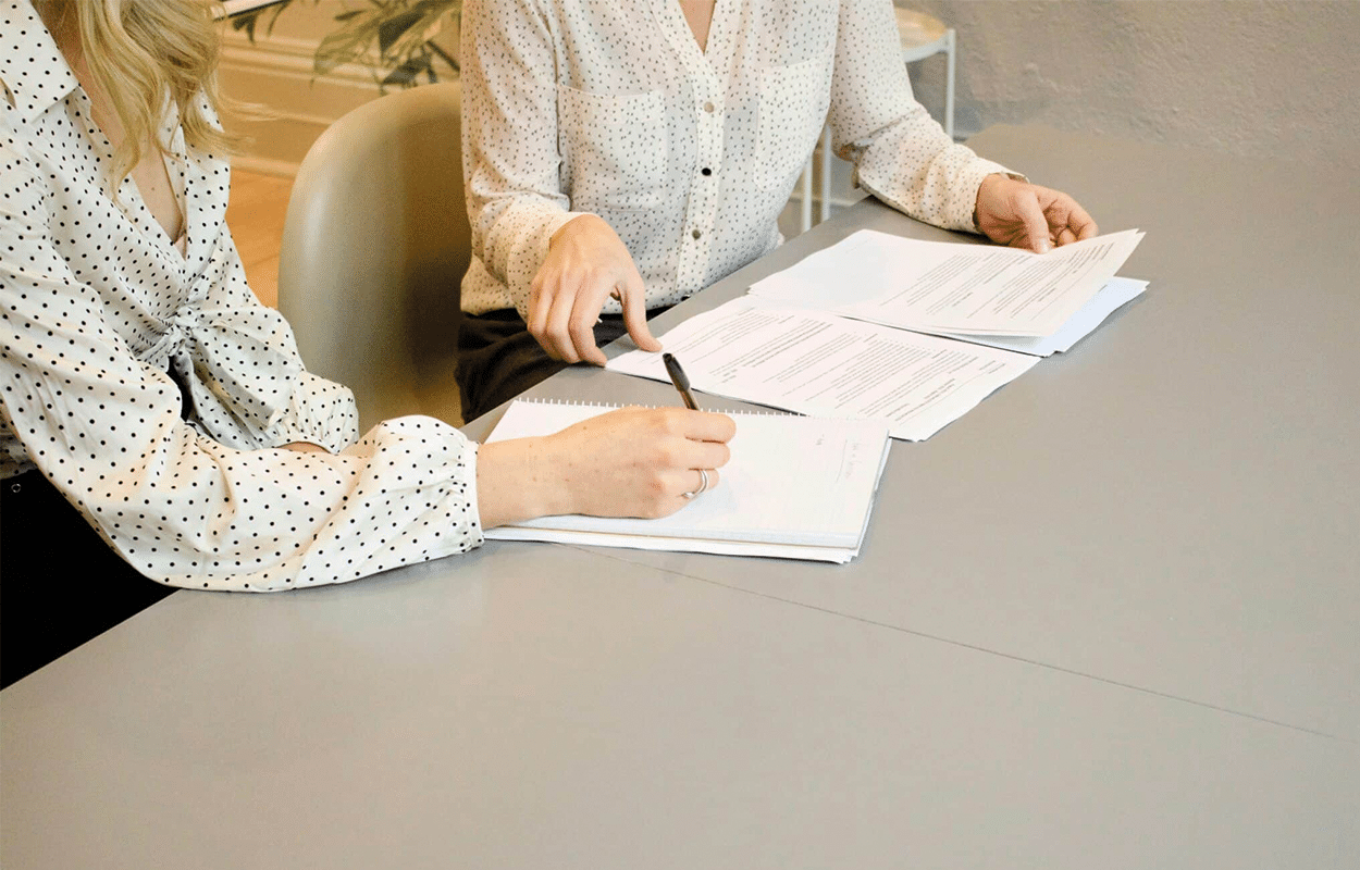 Personne qui signe un papier et une personne aidant cette dernière