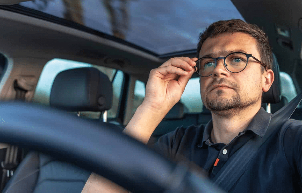 Hommes qui conduite une voiture et porte des lunettes