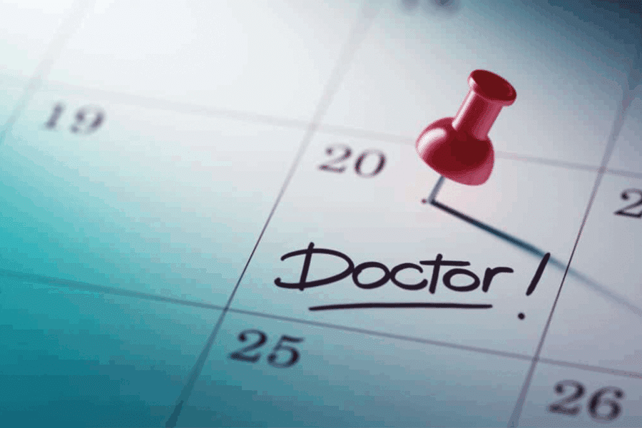 Calendrier avec une punaise qui indique un rendez-vous chez le médecin