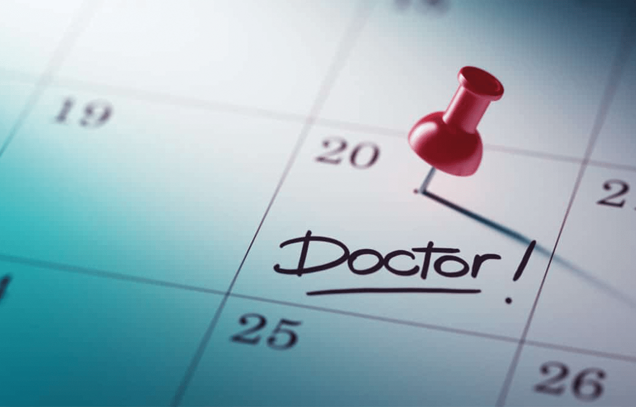 Calendrier avec une punaise qui indique un rendez-vous chez le médecin