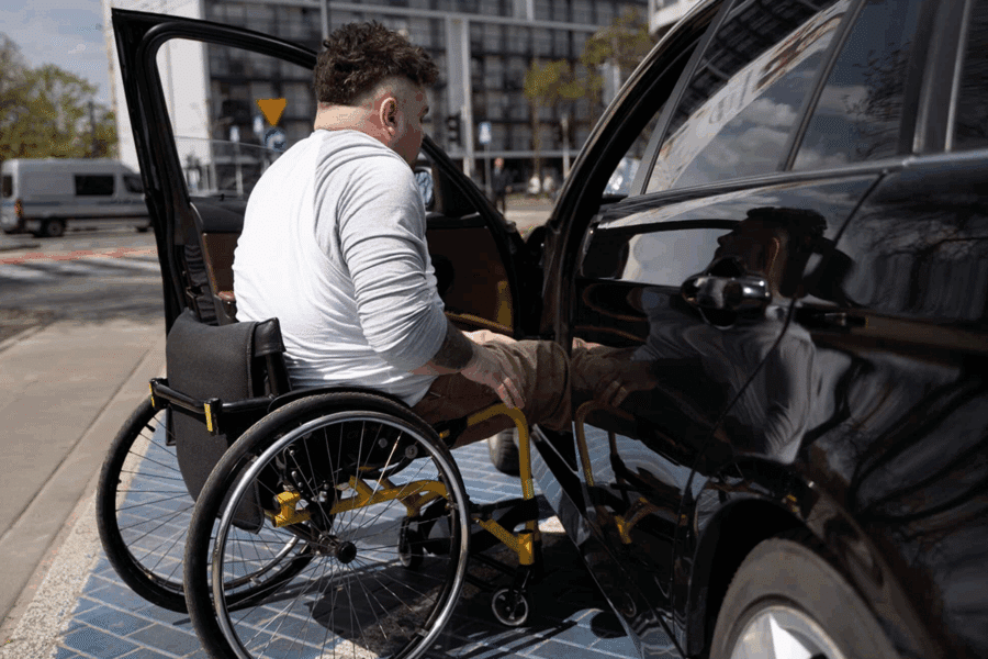personne en fauteuil roulant montant dans son véhicule