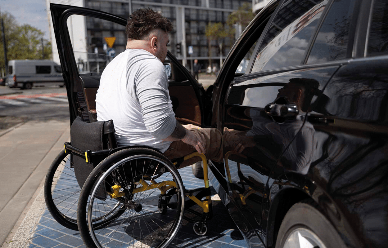personne en fauteuil roulant montant dans son véhicule