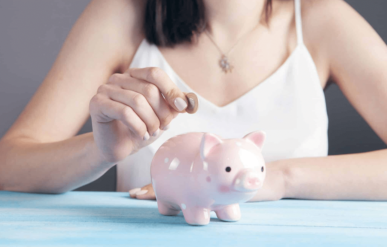 femme mettant une pièce dans une tirelire