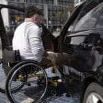 personne en fauteuil roulant montant dans son véhicule
