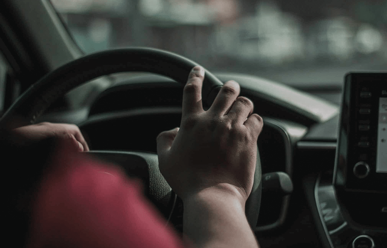 Une main sur le volant d'une voiture