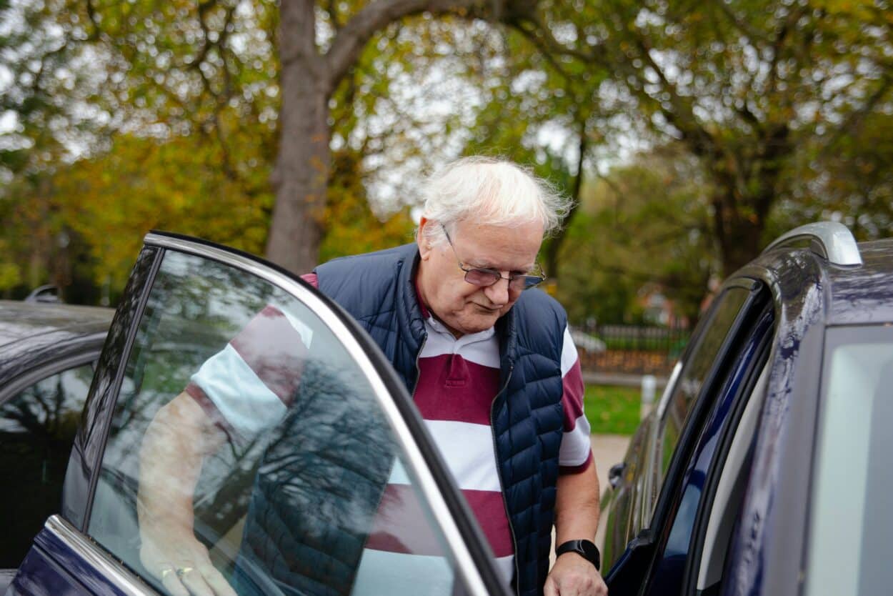 Papi montant dans une voiture du côté passager