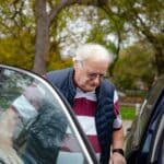 Papi montant dans une voiture du côté passager